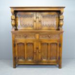 A 1920s two-section court cupboard, with linenfold carved decoration. 122x145x46cm.