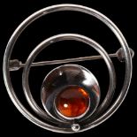 N E FROM, DANISH - a sterling silver and amber set circular design brooch