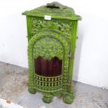 A green painted cast iron station heater, with inset brass oil lamp. H - 66cm.
