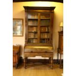 A Regency rosewood cut and line brass inlaid cylinder bureau bookcase, the upper section with pair