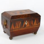 A Regency marquetry inlaid tumbling cube tea caddy, with brass figural ring handles and bun feet,