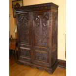 An 19th century oak 2-door cupboard, with 2 heavily relief carved fielded panelled doors, carved and