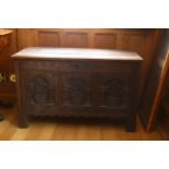 A Charles I oak coffer, with plank lid, the front with 3 panels each carved with a vase of flowers