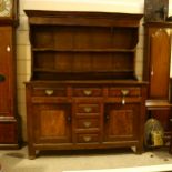 An 18th century oak Welsh dresser, with boarded open plate rack above, 3 frieze drawers with 3 dummy