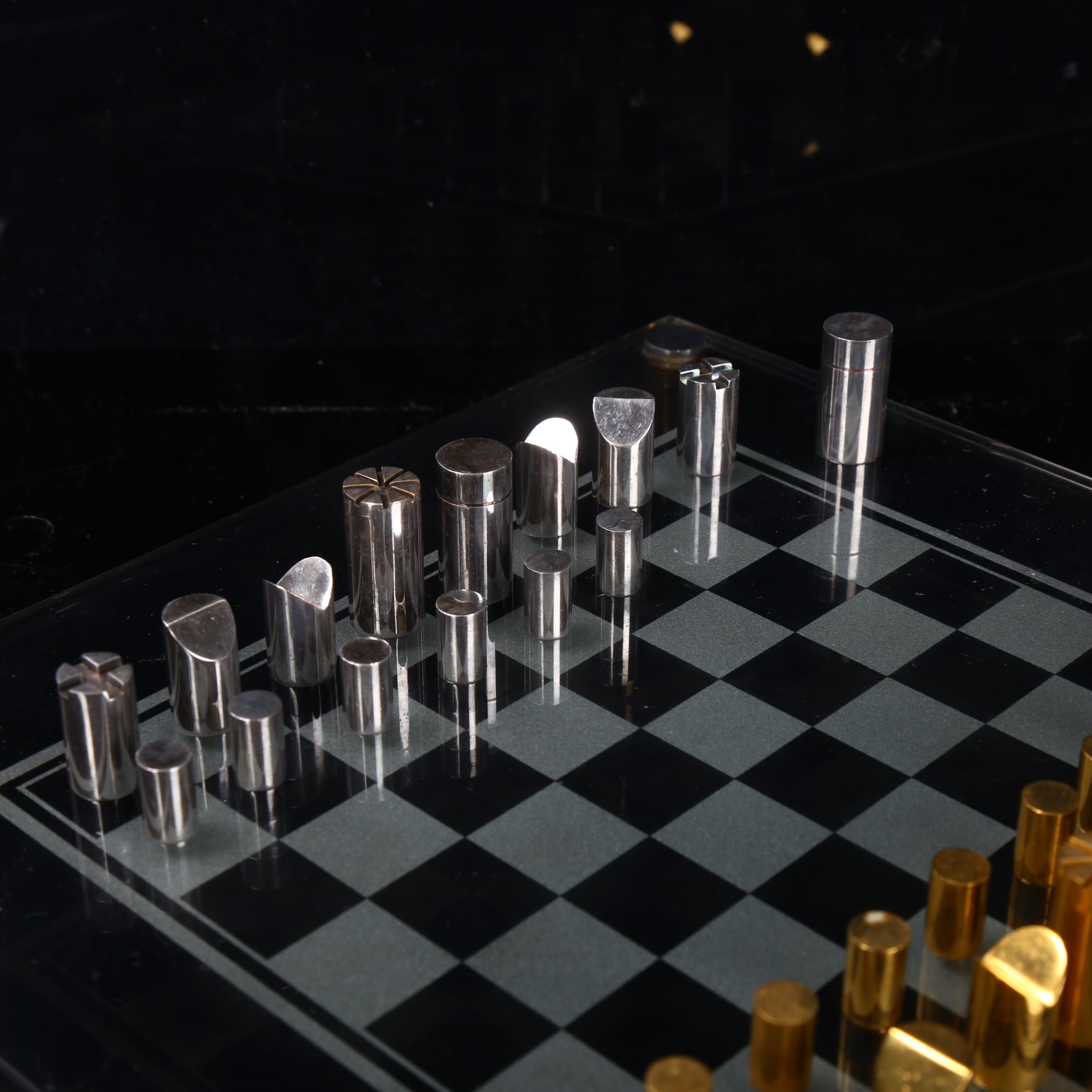 A Modernist hand turned steel and brass chess set, with glass chess board in original leather - Bild 2 aus 3