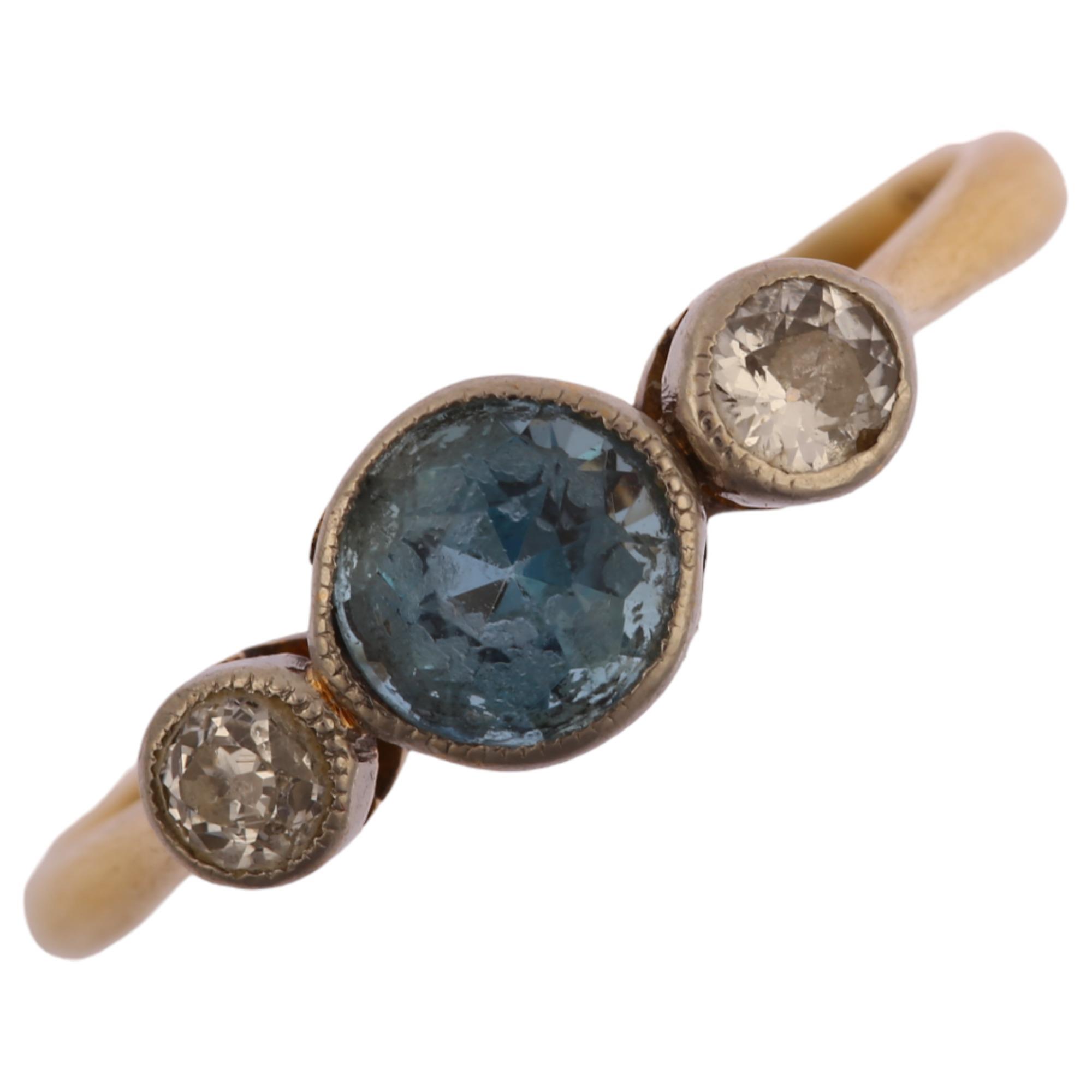 An early 20th century 18ct gold three stone aquamarine and diamond ring, bezel set with round-cut