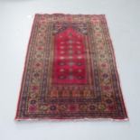A red-ground Persian prayer rug. 135x90cm.