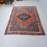 A red-ground Persian design rug. 198x140cm.