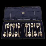 A set of 12 George V silver teaspoons with matching tongs, in original fitted case, retailed by