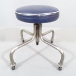 A mid-century modernist tubular steel industrial height adjustable stool with blue leather seat.