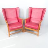 A pair of Parker Knoll style teak and faux-leather upholstered wingback armchairs.