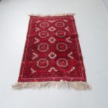 A red-ground Buchara rug. 146x90cm. Fading to lower quarter. Some damage to fringe.
