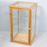 An early 20th century oak framed and glazed shop display cabinet with two glass shelves. 46x76x46cm.