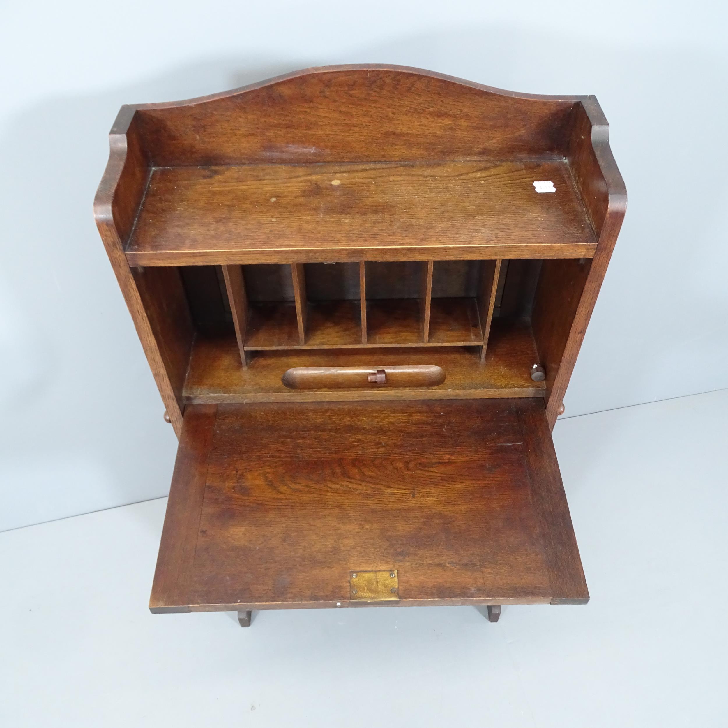 A 1920s oak student's bureau, the fall front revealing a fitted interior with shelves beneath. - Image 2 of 2