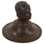 A 19th century patinated iron paperweight, surmounted by a man's head, diameter 10cm