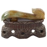 A Chinese carved jade dragon design buckle on hardwood stand, length 8cm Good condition