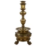 A 19th century brass candle stand on brass lion paw feet, height 32cm