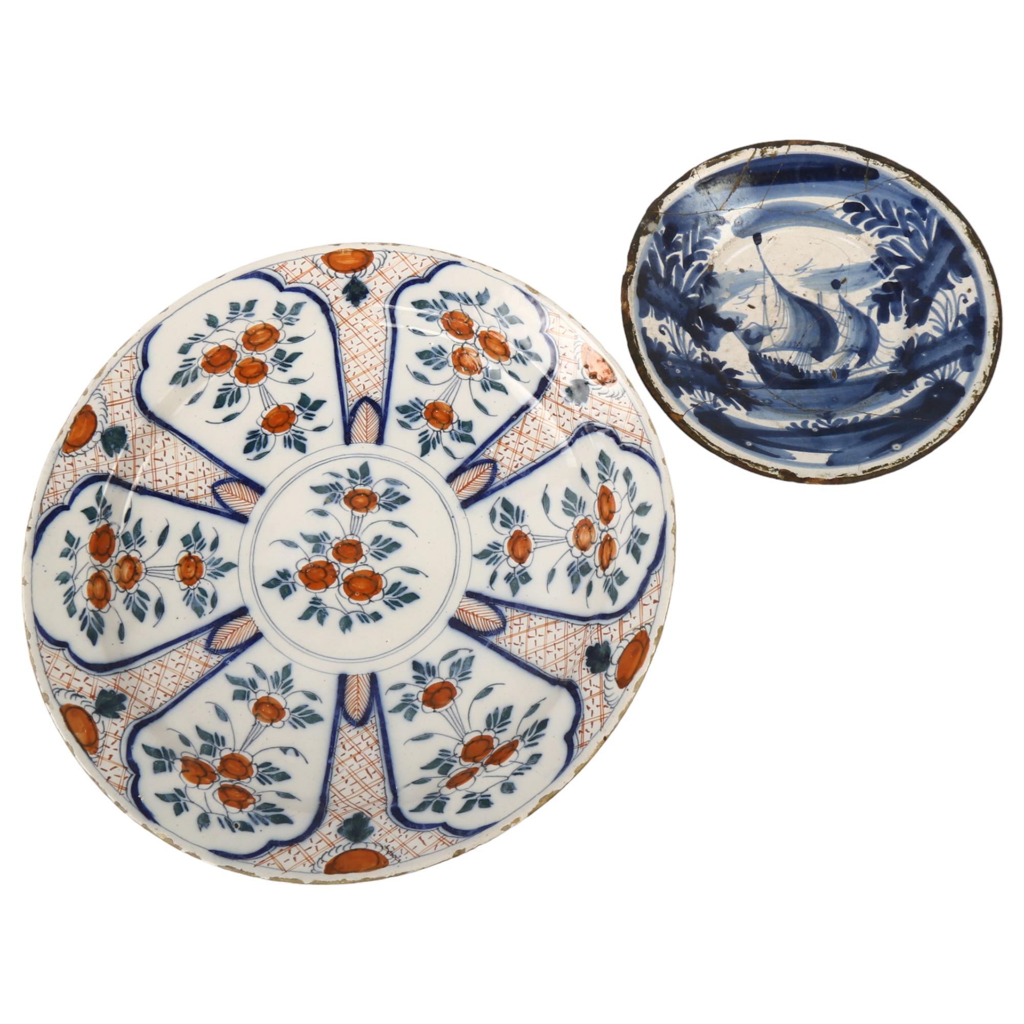 A tin-glazed pottery charger with painted decoration, diameter 24cm, and an early tin-glazed blue