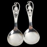 A pair of Art Deco Danish stylised silver preserve spoons, with pierced floral handles, length