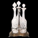 An Elkington & Company silver plated triple bottle stand, fitted with 3 matching decanters on a