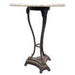 A small circular white and grain veined marble-top side table, sitting on a cast-iron base with