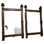 A pair of oak Arts and Crafts wall-hanging mirrors, with turned mounts, 81cm x 50cm