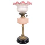 A Victorian oil lamp with fluted brass column, pink glass font, chimney and etched glass shade,