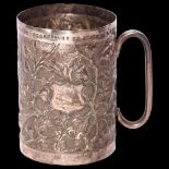 A Chinese white metal mug, with embossed and repousse floral decoration, with inscription to the top