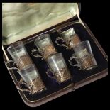 A set of 6 Oriental silver and glass tots, with engraved decoration