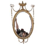 An oval gilt-wood mirror, with sculpted wooden decoration and bevelled-edge glass, 74cm x 44cm