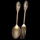 A cased George V silver spoon and fork, with pierced figural decorated handles, hallmarks for London