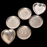 A pair of silver heart-shaped pin dishes, together with a set of 4 Persian white metal coasters