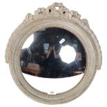 A 1930s limed oak circular convex wall mirror, with ribbon pediment, diameter 41cm