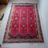 A red-ground Persian carpet. 293x198cm. Some fraying to edges. Some moth damage.