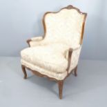 A continental mahogany and upholstered lounge chair, with carved decoration and raised on five legs.
