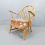 A mid-century beech Windsor lounge chair in the manner of Ercol, with cushion over sprung seat.