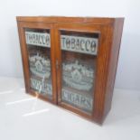 An antique mahogany tobacconist themed shop display cabinet with two glazed doors and three fixed