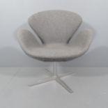 A mid-century style swivel lounge chair in the manner of the Arne Jacobsen Swan chair.