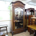A French walnut arch top armoire, circa 1900, with single mirror door, maple panels, and shelved