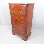 A reproduction mahogany chest of eight drawers, with brushing slide, carved decoration and bracket