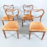 A set of four Victorian rosewood and upholstered balloon back dining chairs.