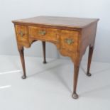 A George I 18th century oak lowboy writing desk, with three drawers, tapered legs and spade feet.