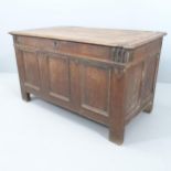 An 18th century panelled oak coffer. 116x67x60cm. Some damage and wear, particularly to rear of