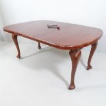 An antique mahogany wind-out dining table, with single spare leaf and winding handle. Dimensions (