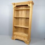 A modern pine open bookcase, with carved decoration, three adjustable and one spare shelf and drawer