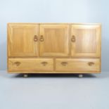 A Mid-Century Ercol Windsor model 468 sideboard, in Golden Dawn with three cupboards and drawers