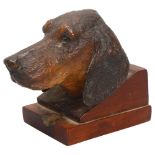 A Black Forest carved and stained wood sculpture of a hound's head, with glass eyes, on block