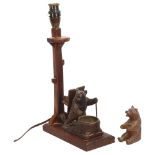 A Black Forest table lamp with carved wood bear mount, and a small Black Forest seated bear ornament