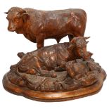 A superb 19th century Black Forest carved wood sculpture of a bull cow and calf, on naturalistic