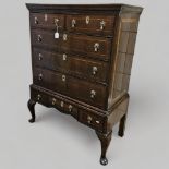 A George III walnut chest on stand raised on cabriole legs, width 94cm, height 127cm Veneer splits